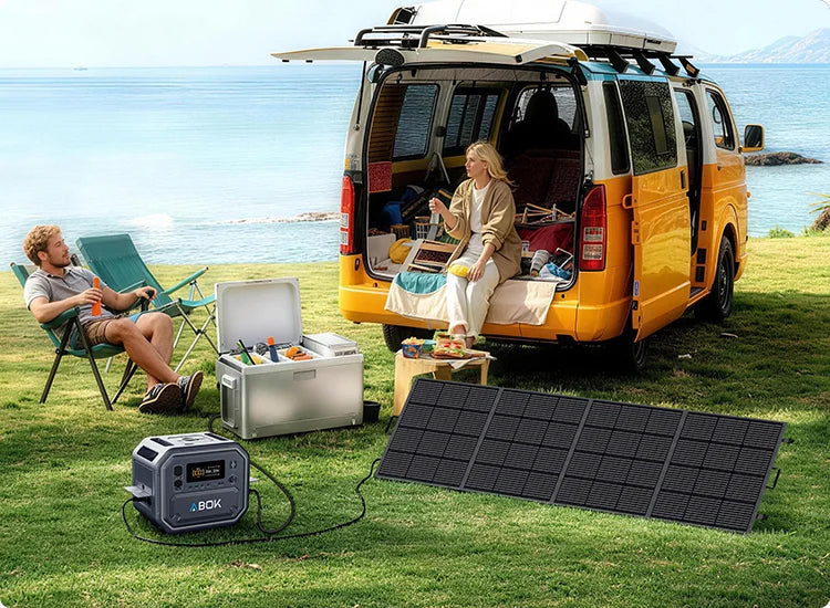 ABOK Ark2500 mobile seaside camping scene with the portable power station connected to a foldable solar panel beside a camper van